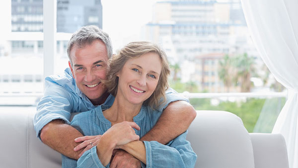 older couple holding each other on the couch smiling